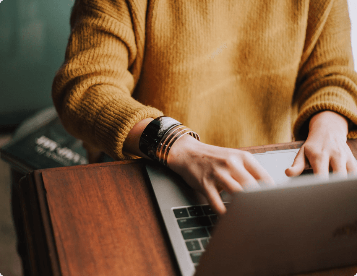 Person typing on a laptop at a desk to send the DealersLoop team a message